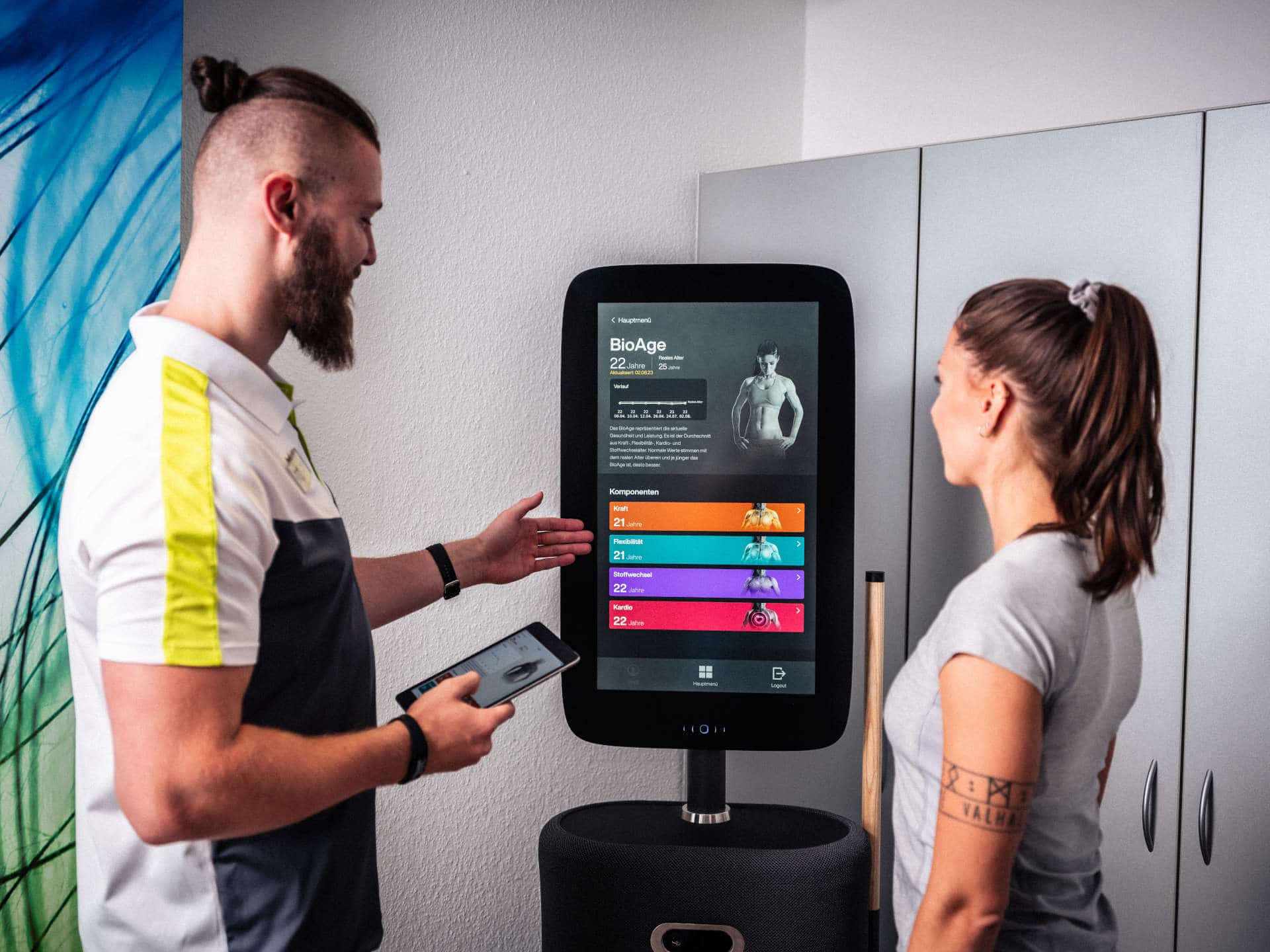 Trainer erklärt BioAge-Auswertung am EGYM-Display